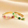 Pink and Green Enamel Adjustable Rings in Gold Stacked on Beige Ribbed Fabric