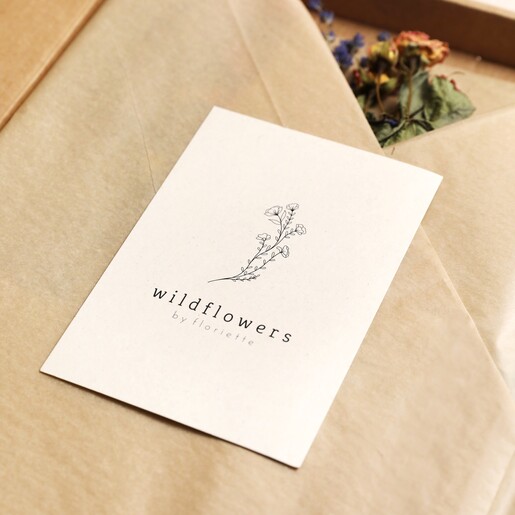 Brand card from the Dried Wildflowers and Trio of Vases Gift Set on top of packaging