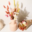 Mum Yellow and Pink Small Dried Flower Bouquet Inside Pink Vase Beside Wrapped Bouquet