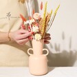 Model Arranging Mum Yellow and Pink Small Dried Flower Bouquet Into Pink Vase