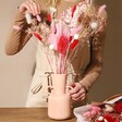 Model Arranging Vibrant Valentine's Dried Flower Bouquet in Vase on Table