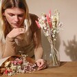 Model Looking at Vintage Pink Market Style Dried Flower Bouquet in Vase and Paper