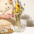 Model Arranging Flowers in Vase from the Yellow and Blue Dried Flowers Letterbox Gift