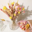 Yellow and Pink Dried Flower Bouquet Inside Glass Vase Beside Wrapped Bouquet