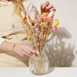 Model Arranging Yellow and Pink Dried Flower Bouquet into Glass Vase