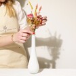 Model Arranging Yellow and Pink Dried Flower Posy Into Included White Vase