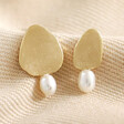 Mismatched Pearl and Organic Shape Stud Earrings on Neutral Fabric