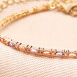 Close Up of Pastel Baguette Crystal Bracelet in Gold on Beige Fabric