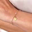 Close Up of Model Wearing Beaded Pearl Heart Charm Bracelet in Gold