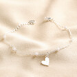 Beaded Pearl Heart Charm Bracelet in Silver on Beige Fabric