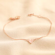 Personalised Initial Shiny Heart Charm Bracelet in rose gold against beige coloured material