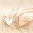 Close up of Personalised Initial Shiny Heart Charm Bracelet	in silver and rose gold against beige coloured fabric