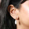 Close up of Sun and Pearl Drop Earrings in Gold on dark haired model