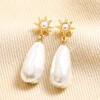 Sun and Pearl Drop Earrings in Gold on top of beige coloured fabric