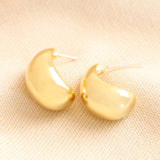 Chunky Teardrop Half Hoop Earrings in Gold Chunky Teardrop Half Hoop Earrings in Gold on beige fabric