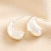 Chunky Teardrop Half Hoop Earrings in Silver on beige fabric