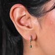 Close Up of Green Crystal Huggie Hoop Earrings in Gold on Model