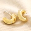 Small Crystal Hammered Half Hoop Earrings in Gold on beige fabric