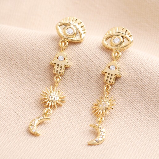Hamsa Hand Drop Earrings in Gold on a Beige Background