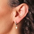 Close Up of Opal Diamond Huggie Hoop Earrings in Gold on Model