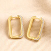 Rectangular Crystal Huggie Hoop Earrings in Gold on Beige Fabric