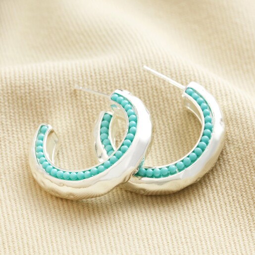 Teal Stone Hammered Hoop Earrings in Silver on Beige Surface