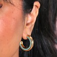 Close Up of Teal Stone Hammered Hoop Earrings in Gold on Model's Ear