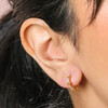 Close Up of Tiny Heart and Crystal Huggie Hoop Earrings in Gold on Model