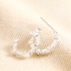 Tiny Heart and Crystal Huggie Hoop Earrings in Silver on Beige Fabric