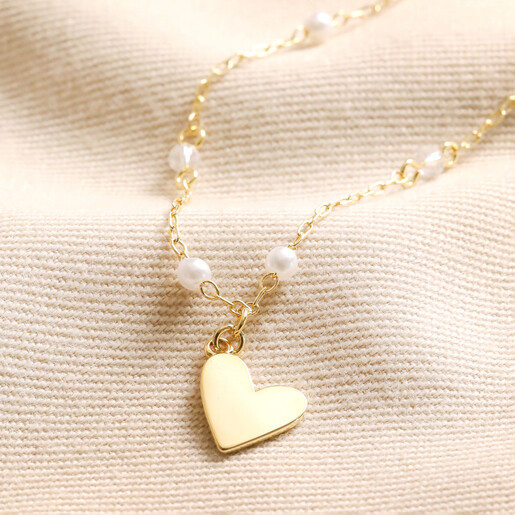 Beaded Pearl Heart Pendant Necklace in Gold Beaded Pearl Heart Pendant Necklace in Gold on Beige Fabric