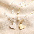 Beaded Pearl Heart Pendant Necklaces in Gold and Silver on Beige Fabric