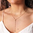 Close Up of Shell Moon and Star Lariat Necklace in Gold on Model