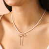 Close Up Model  Shot of Pearl Necklace with Large Bow Pendant in Gold