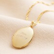 Personalised Oval Locket Necklace in gold against neutral coloured material