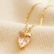 Pink Faceted Crystal Heart Pendant Necklace in Gold on Beige Fabric