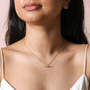 Crystal Feature T-Bar Pendant Necklace in Gold on model in front of beige coloured backdrop