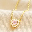 Tiny Pink Crystal Heart Pendant Necklace in Gold on Beige Fabric