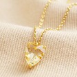 Yellow Faceted Crystal Heart Pendant Necklace in Gold on Beige Fabric