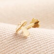 Tish Lyon Solid Gold Toadstool Helix Earring on top of neutral fabric