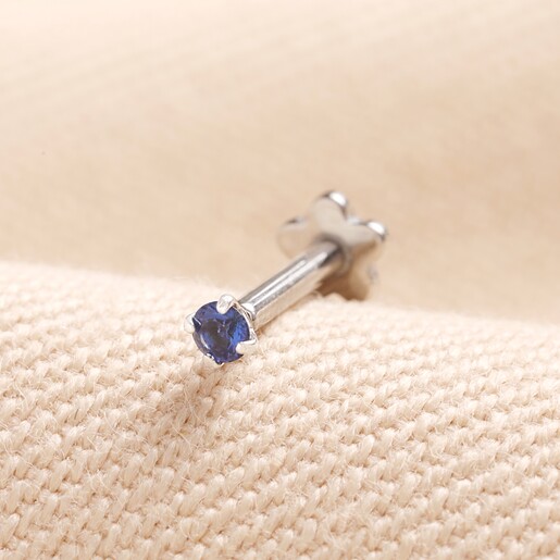 Tish Lyon Solid White Gold Blue Crystal Helix Earring on top of beige coloured fabric