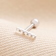 Tish Lyon Solid White Gold Crystal Microbar Barbell on top of beige coloured fabric