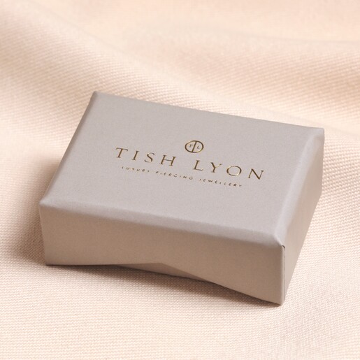 Tish Lyon Solid White Gold Blue Crystal Helix Earring inside of gift box on top of beige fabric
