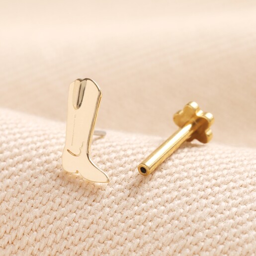 Tish Lyon Solid Gold Cowboy Boot Helix Earring on top of neutral coloured material