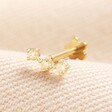 Tish Lyon Triple Champagne Crystal Solid Gold Helix Earring on top of beige coloured fabric