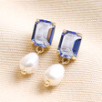 Big Metal London Blue Crystal and Pearl Drop Earrings in Gold on Beige Fabric