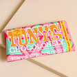 Tony's Chocolonely Milk Chocolate Everything Bar on top of beige coloured backdrop