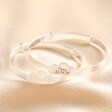 Personalised Sterling Silver Cloud Christening Bangles stacked on top of each other against beige fabric