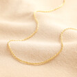 Gold Plated Sterling Silver Trace Chain on top of beige coloured fabric