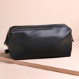 Men's Vegan Leather Wash Bag in Black on Beige Surface