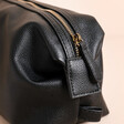 Close Up of Side Poppers on Men's Vegan Leather Wash Bag in Black